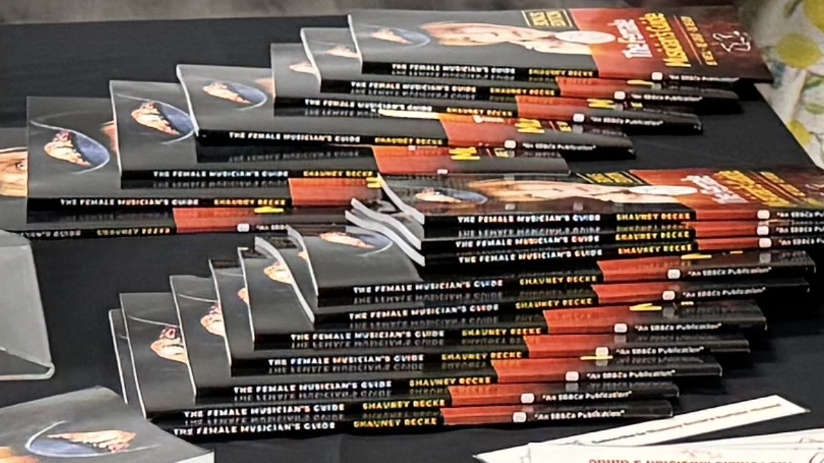 Copies of The Female Musician's Guide laid out on a signing table